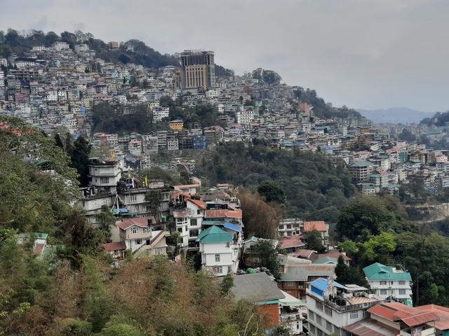       Hillside cityscape with buildings densely packed across a sloping terrain.
  