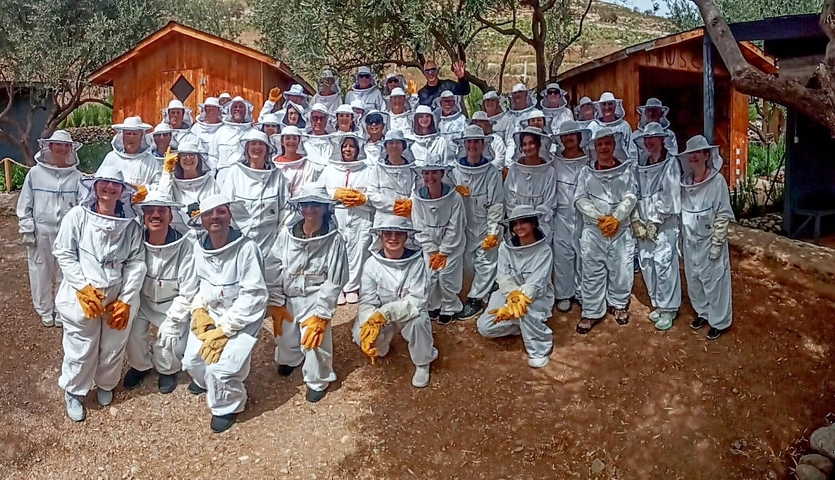 Group photo of people in beekeeper outfits.