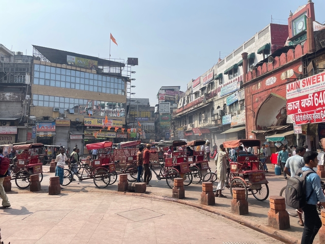       Street scene with many cycle rickshaws and shops.
  