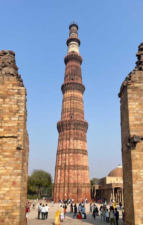       Tall monument made from red sandstone framed between stone walls.
  