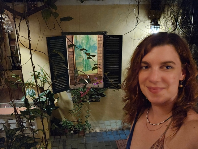       Woman posing in front of a vintage style window display.
  