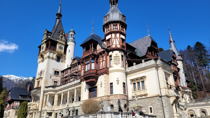 Ornate castle with multiple towers and decorative facades against a clear sky.