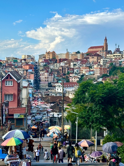       Panoramic view of a bustling hillside town with colorful houses.
  