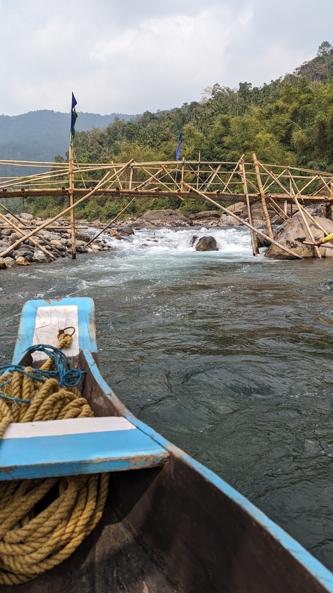       River with bamboo structures and rocks
  