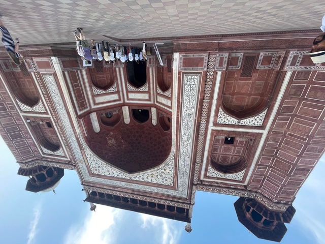       Visitors at the entrance of an ornate historical structure.
  