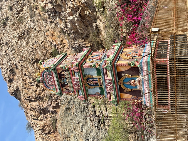       Colorful temple facade against a rocky backdrop.
  