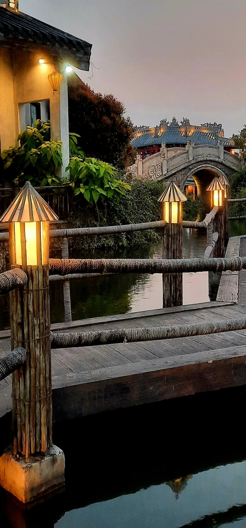       Bridge over a body of water with lanterns.
  