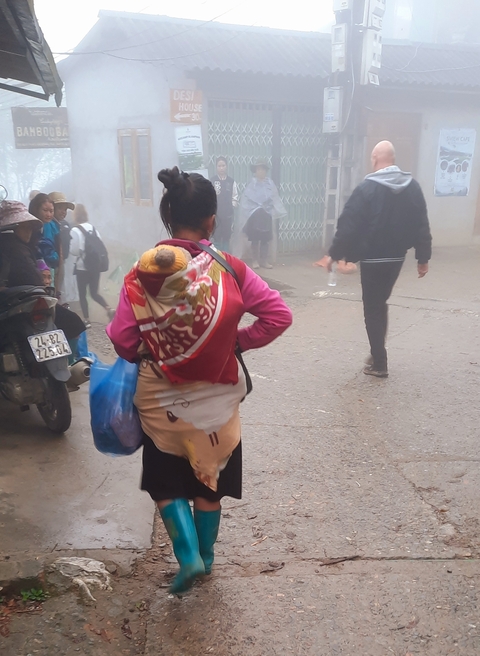       Person carrying items in a misty street.
  