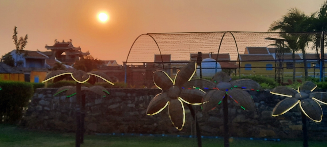 Art installation with flowers lighting up at sunset.