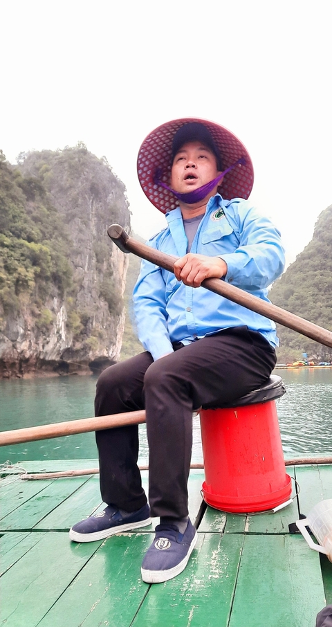       Person rowing a small boat on a calm body of water.
  