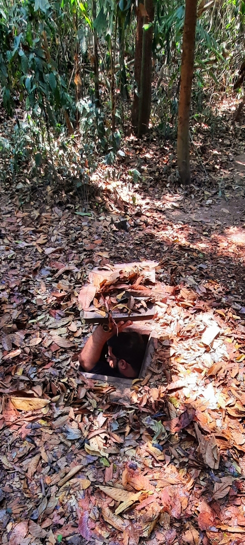 Person emerging from a camouflaged trapdoor.