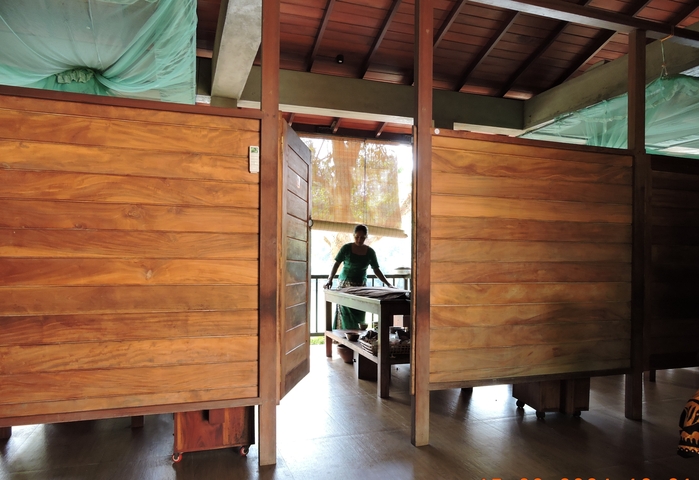 Woman standing at a wooden counter in an open setting
