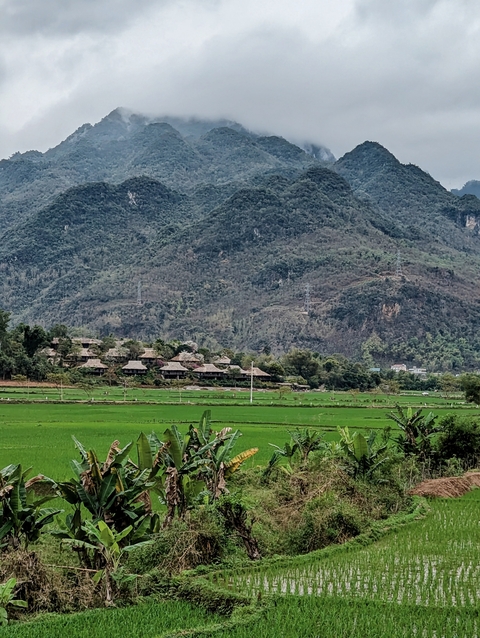       Beautiful landscape with green fields and a mountain range.
  