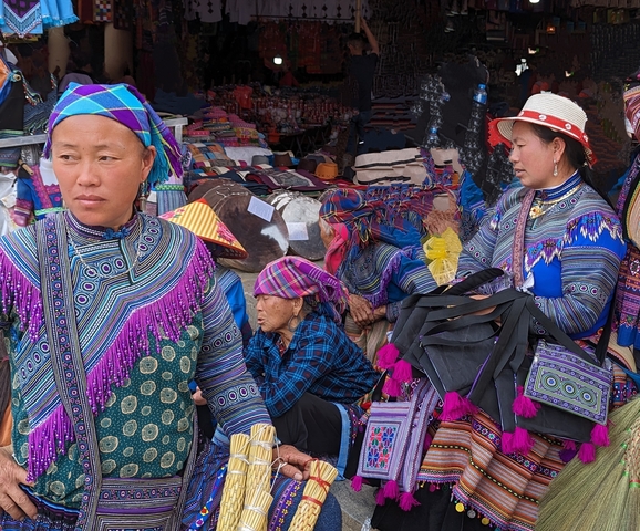       Market scene with people in vibrant traditional dress.
  
