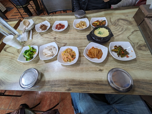 Korean meal with various side dishes on a table.