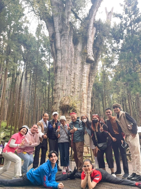       Group posing in front of a huge tree
  