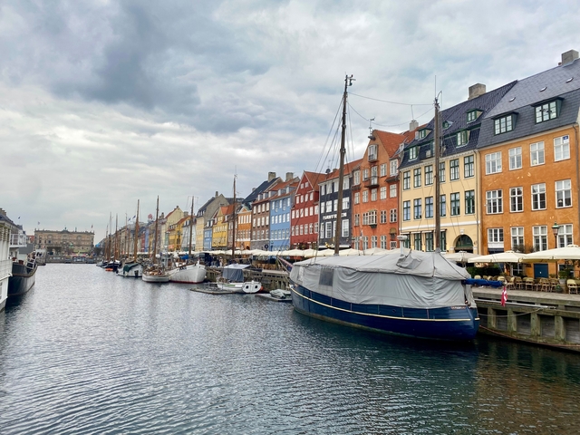Cobblestone waterfront with colorful buildings and boats