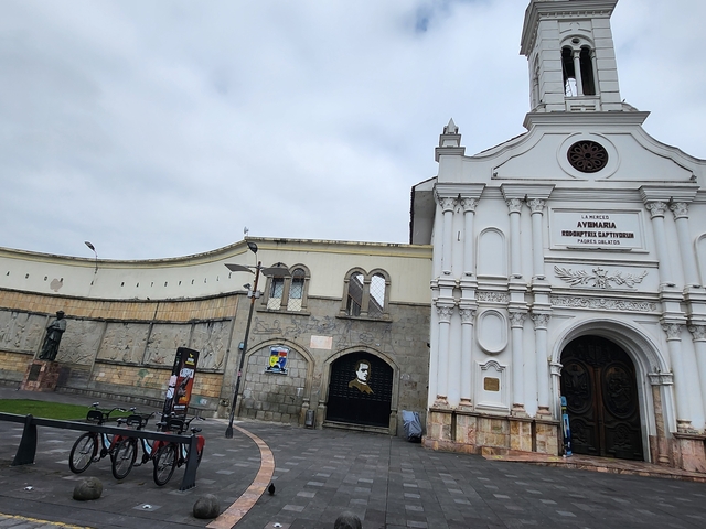       White church with intricate architecture and a curved wall.
  