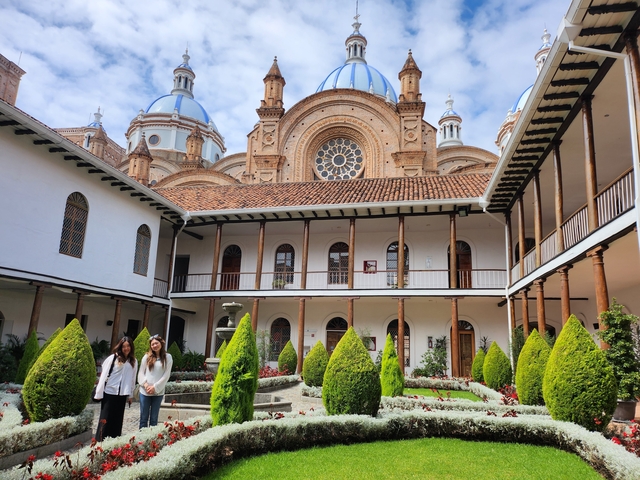 Courtyard with a historic building and two people posing.