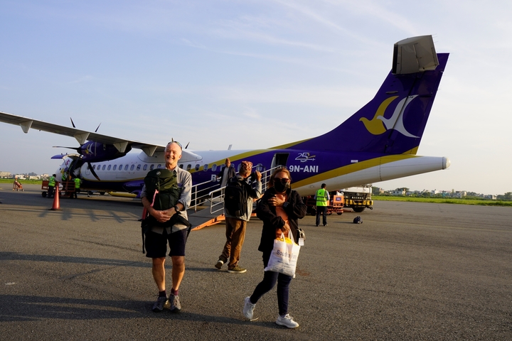 People disembarking from an airplane on a tarmac.