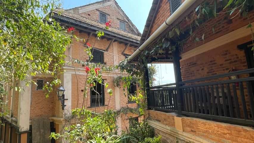       Brick colonial-style buildings surrounded by greenery.
  