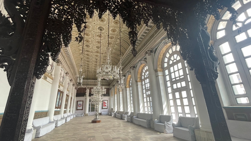      Interior of a grand hall with chandeliers and arches.
  