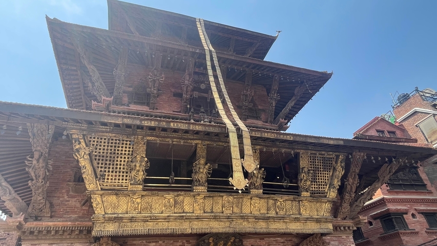       Intricately carved temple with blue sky background.
  