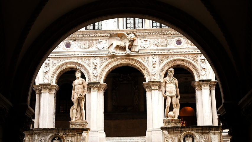       Statues at the entrance of a historic building.
  