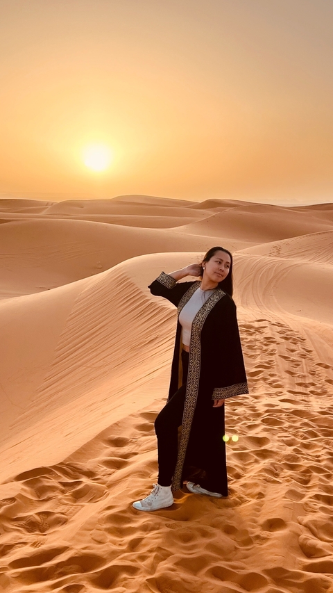       Person posing in Moroccan desert sand dunes.
  