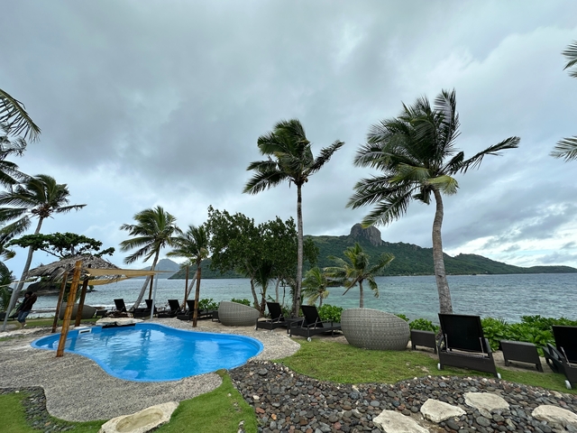 Tropical resort setting with a pool and ocean view.