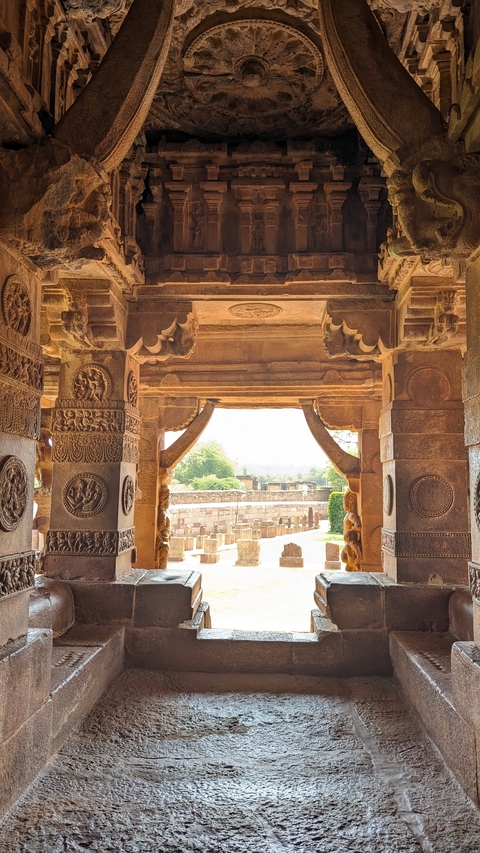       Stone temple entrance with intricate carvings viewed from interior.
  