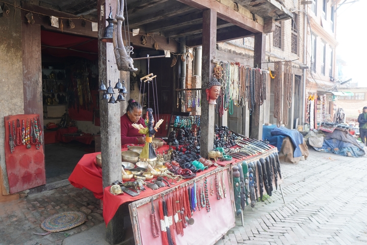       A market stall with various items for sale, including jewelry and ornaments.
  