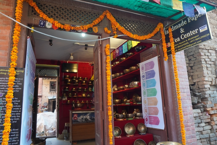       A shop entrance with goods displayed and marigold garlands decorated.
  