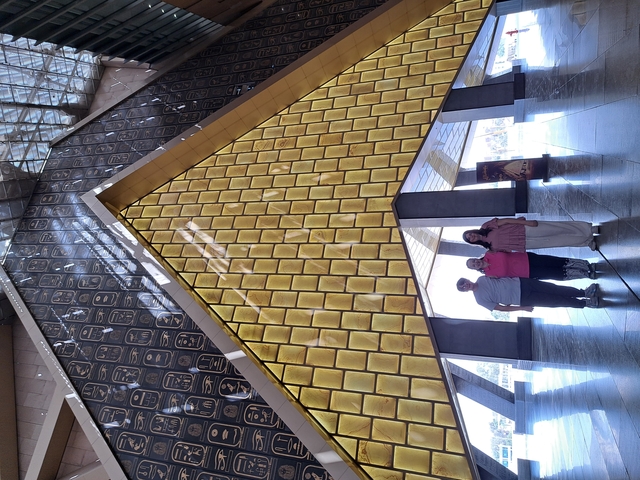 People posing in front of a modern building with gold decor.
