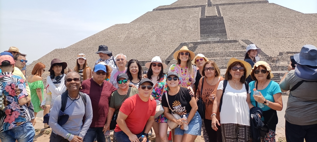 Group posing in front of a pyramid.