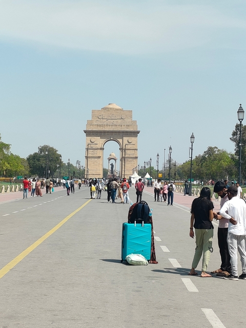 India Gate with tourists walking around.