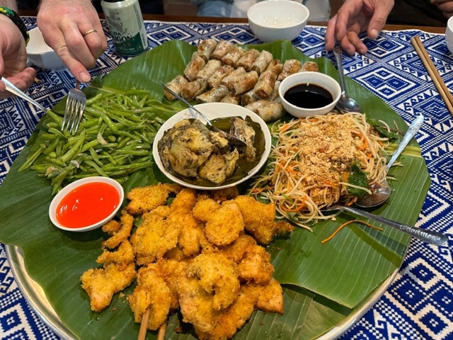Traditional Vietnamese meal with various dishes arranged on banana leaves.