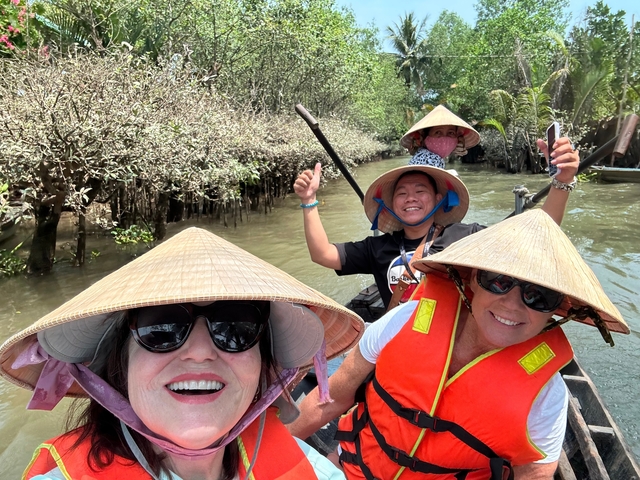       Group of tourists enjoying a boat ride in a mangrove area.
  