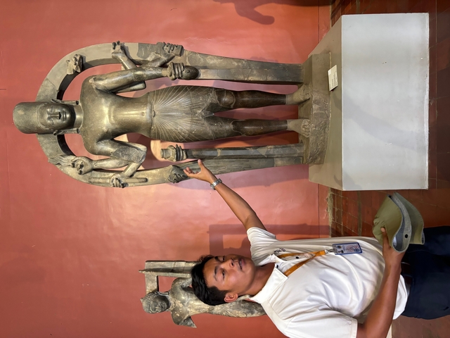       Guide explaining a statue in a museum or gallery.
  