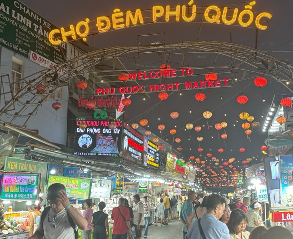       Busy night market with colorful lanterns and signs in Phu Quoc.
  