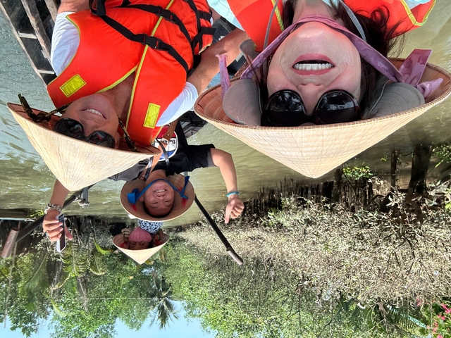       Group enjoying a boat ride in a mangrove while wearing traditional hats.
  