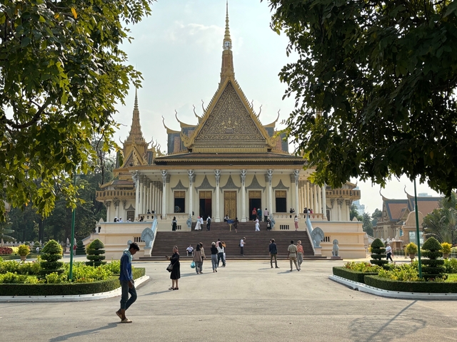 Palace with a wide open courtyard and tourists walking around.