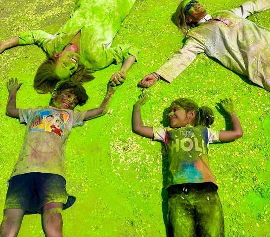       Children playing in colorful Holi powder.
  
