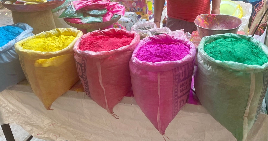       Sacks of colored Holi powder in a market.
  