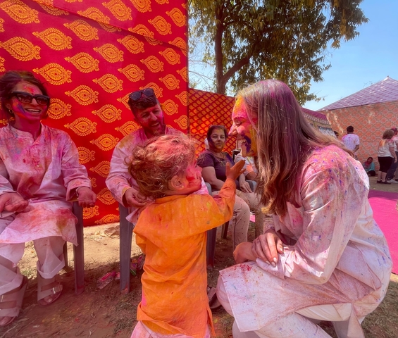       Family playing with Holi colors.
  