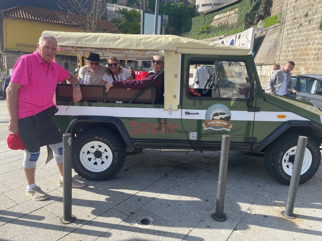 Group of people posing with a jeep labeled 'Happy Tribe'.