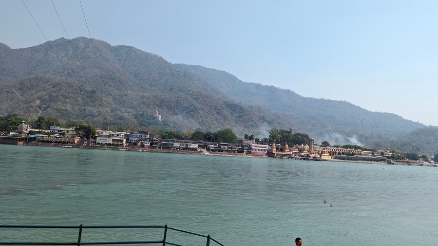 View across a river to a town with mountains in the background.