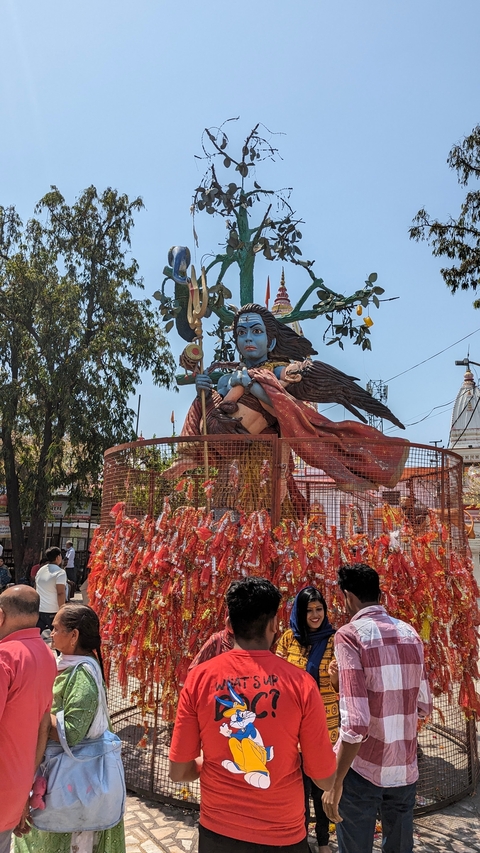 Large colorful statue in a fenced area.