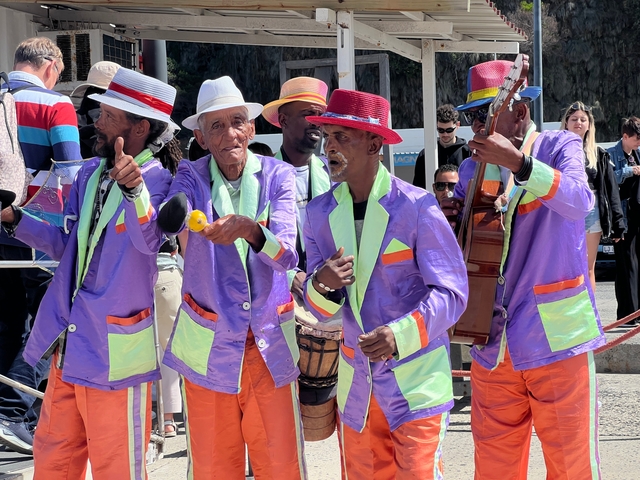       Colorful performers in traditional attire playing music.
  