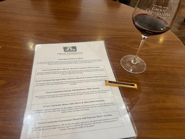       Wine glass and tasting menu on a table.
  